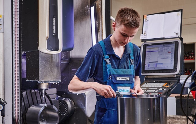 Zerspanungsmechaniker prüft Teile