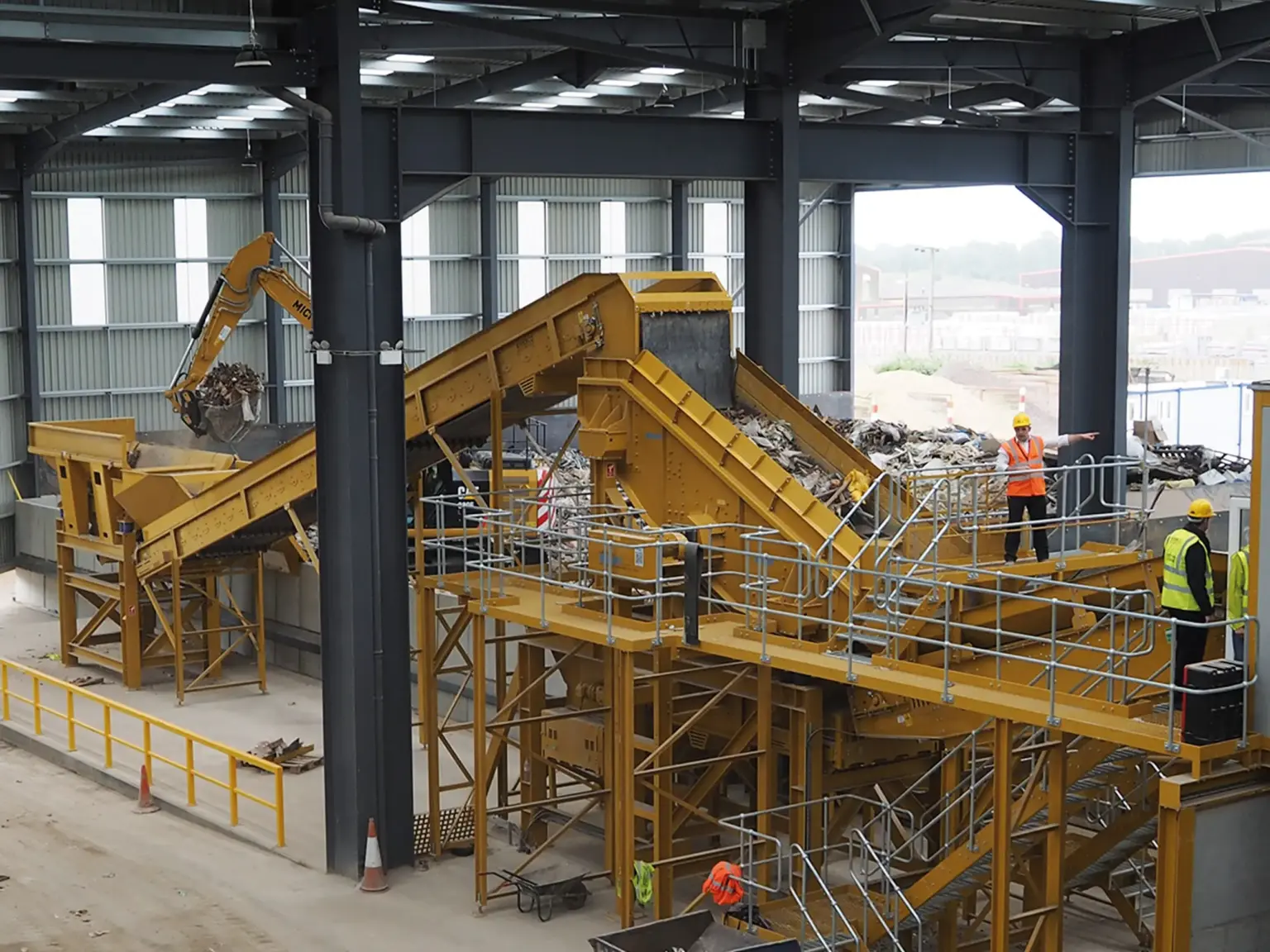 Industrieanlage mit Förderbändern und Wertstoffsieb in einer Halle.