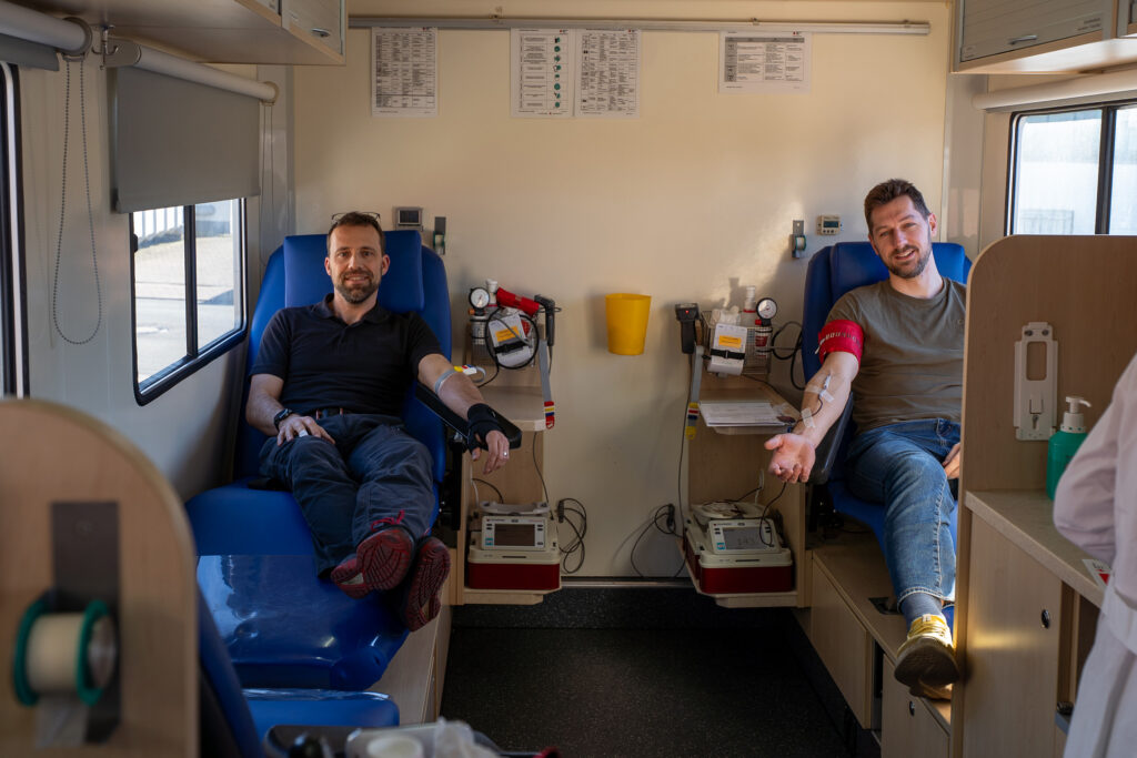 Zwei Spaleck Kollegen spenden Blut im Blutspendebus des DRK bei Blutspendetag von Spaleck