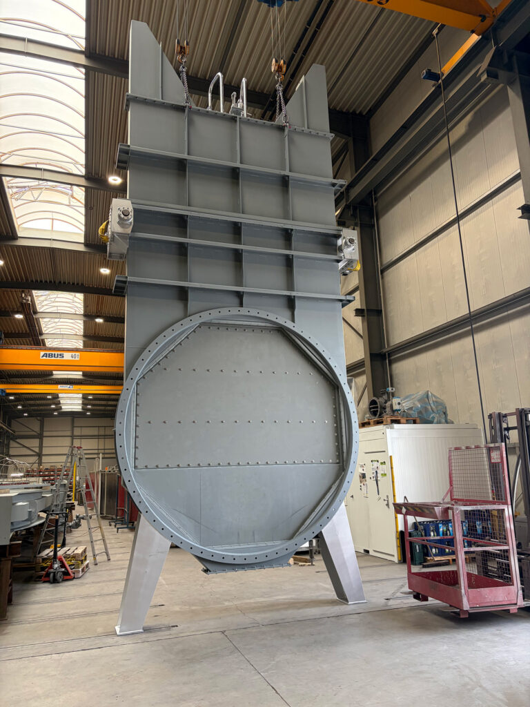Product photo of an XXL gate valve in a production hall during acceptance testing for a cement plant