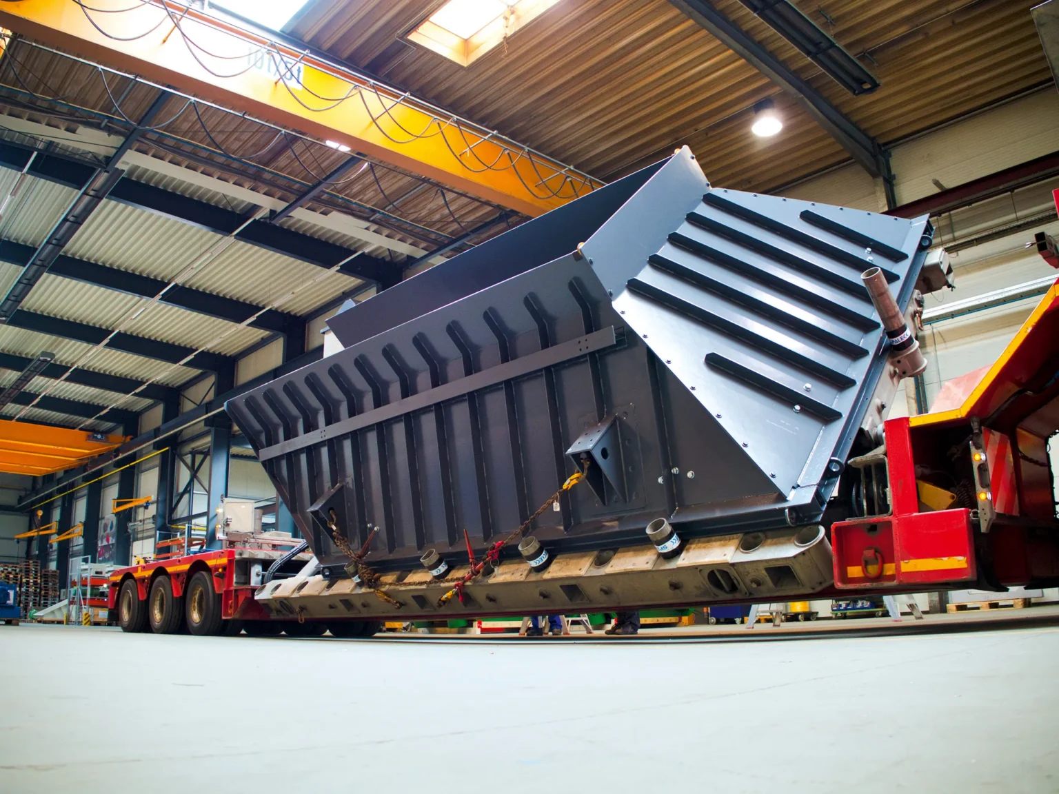 Großer Aufgabebunker von SPALECK auf einem LKW-Trailer. Der Bunker wird ausgeliefert und wird im REcycling von Elektroschrott für die Materialzufuhr des Elektroschrottes in den Recyclingprozess genutzt.