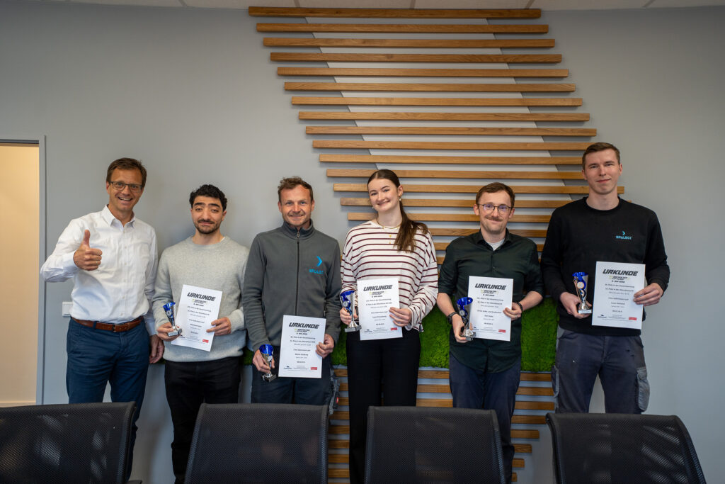 Gruppenfoto der Siegehrung im Spaleck Team mit Pokal und Urkunde, die von Carsten Sühling überreicht werden