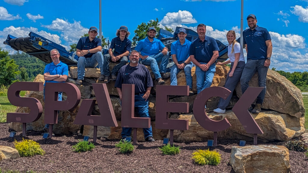 Teamfoto von Spaleck USA am Spaleck Logo in Charleroi bei der Standorteröffnung und blauem Himmel