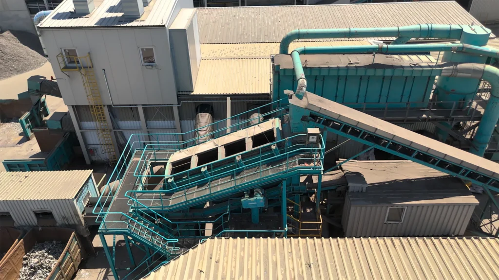 Luftbild einer SPALECK Siebmaschine für das Metallrecycling. Die Maschine ist eingebettet in einer Metallrecyclinganlage und gibt insgesamt drei nach Größe sortierte Fraktionen in die Anlage ab.